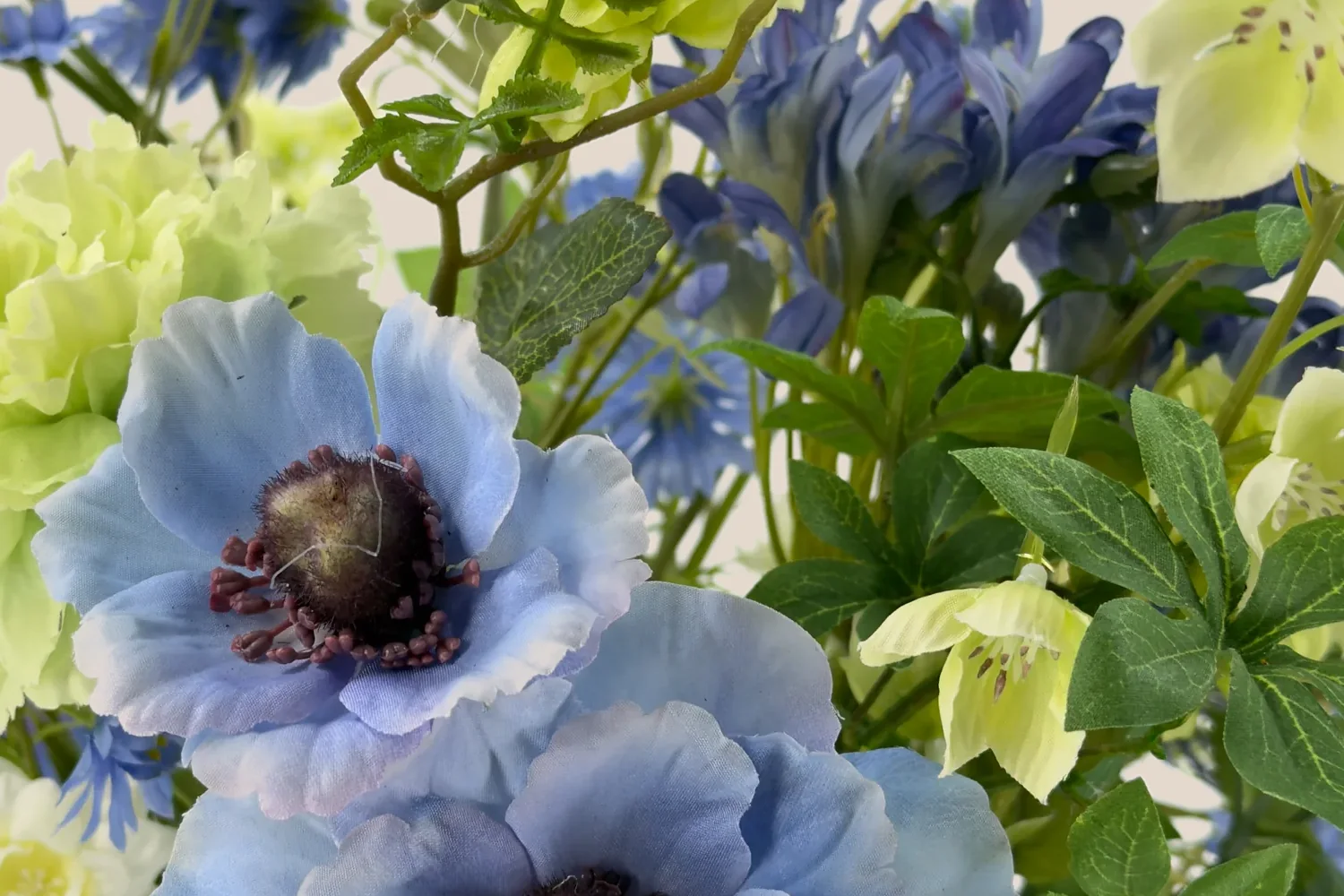 Detail van lichtblauwe en limegroene bloemen met groen blad.