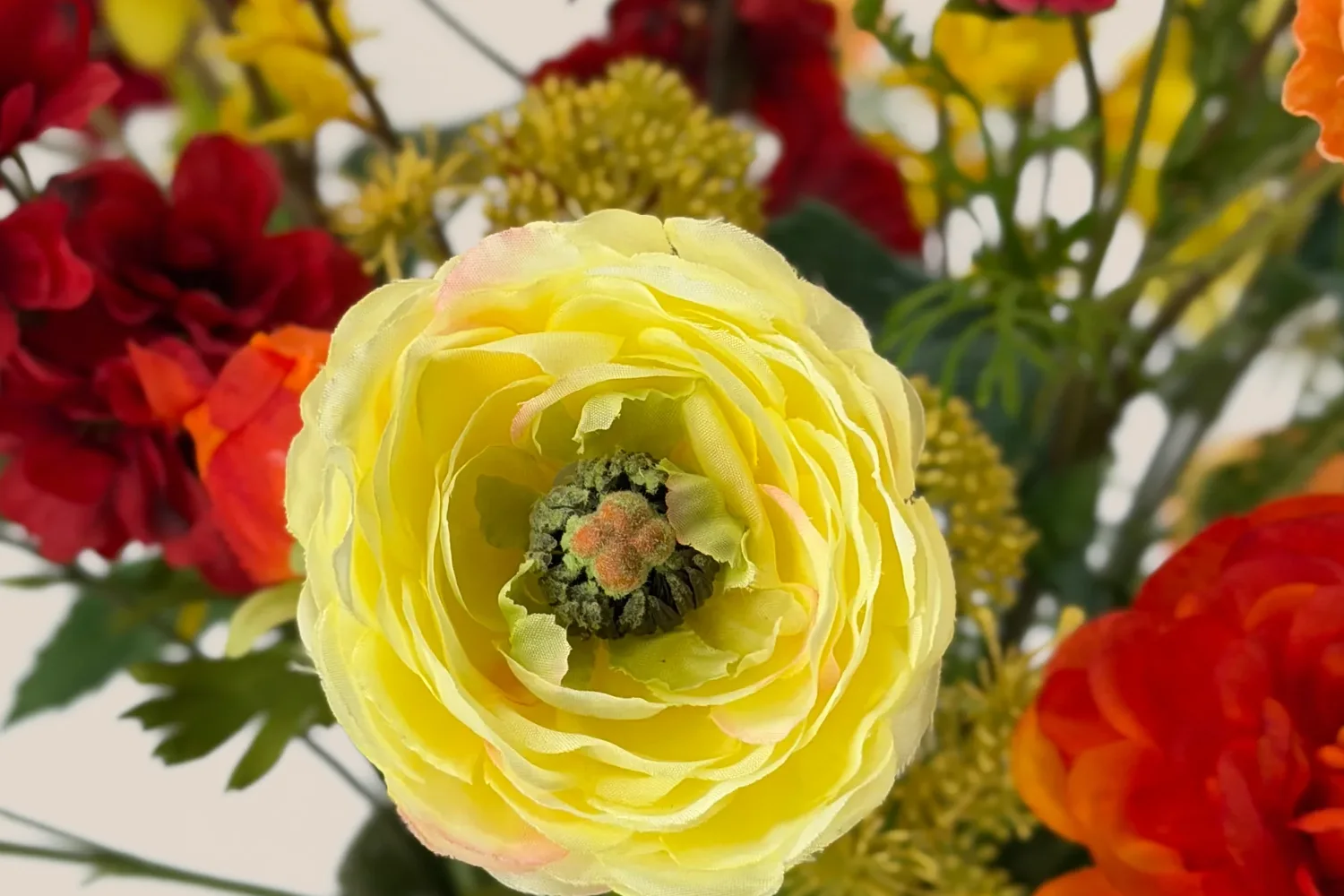 Detail van gele, rode en oranje bloemen met sterk kleurcontrast.