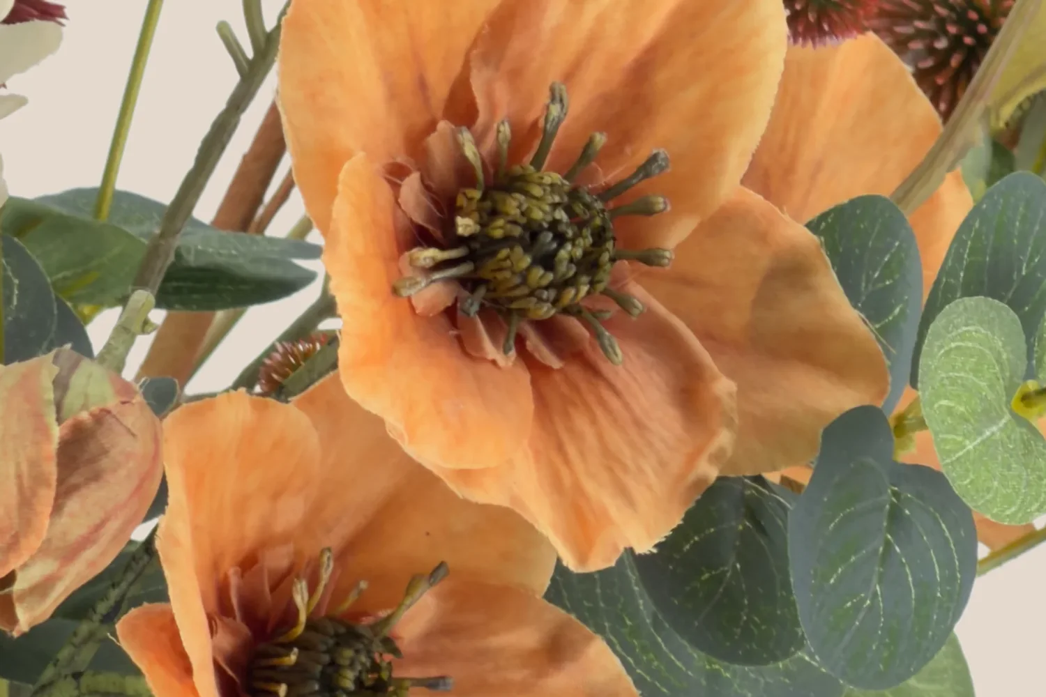 Detail van warme oranje bloemen met vergrijsd groen.